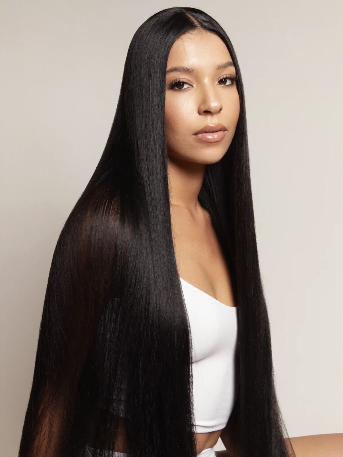 Model with sleek bone straight hair and a natural middle part